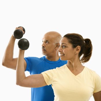 Smiling mid adult multiethnic man and woman exercising with dumbbells doing bicep curls.