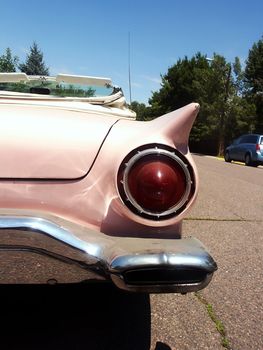 A classic pink American car showing design elements