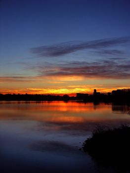 A colorful blue and orange sunrise above a lake