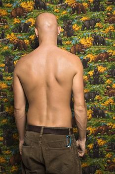 Portrait of a shirtless Mid-adult Caucasian male with back towards viewer.