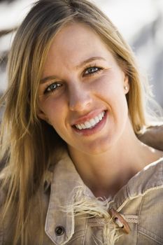 Attractive young adult Caucasian woman with long hair smiling at viewer.