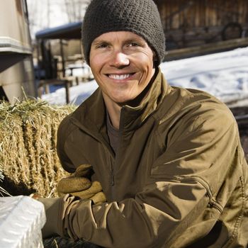Young Caucasian man outdoors in rural setting smiling at viewer.