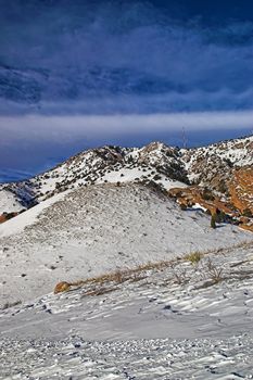 Fresh snowfall and mountains in Colorado against early morning light ad blue skies