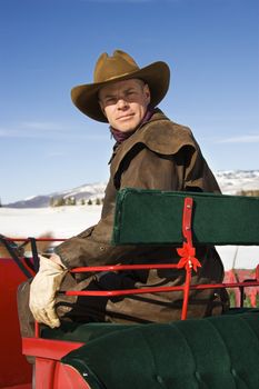 Mid-adult Caucasian man in sleigh looking at viewer.