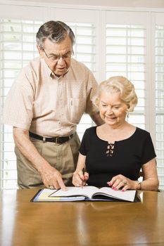 Mature Caucasian couple looking at their calendar.