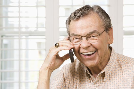 Mature Caucasian man talking on cellphone.