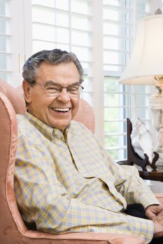 Portrait of mature Caucasian man sitting in chair.