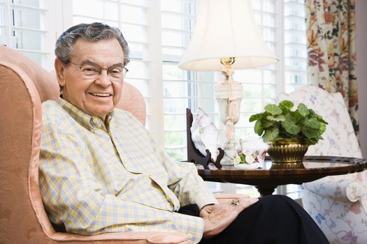 Portrait of mature Caucasian man sitting in chair.