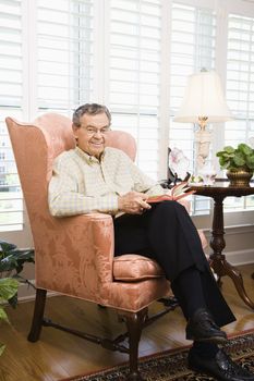 Portrait of mature Caucasian man sitting in chair.