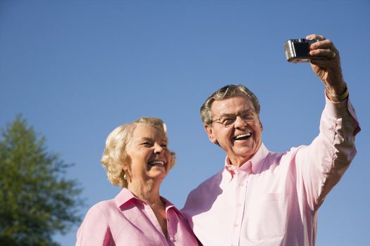Mature Caucasian couple taking picture of themselves.