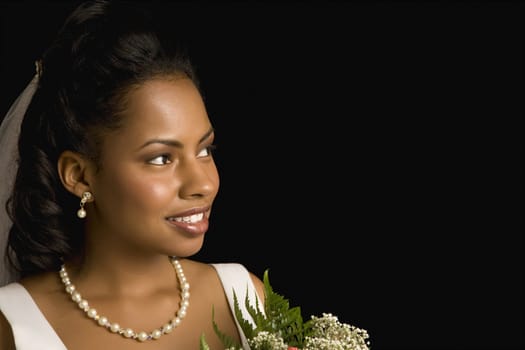 Portrait of a mid-adult African-American bride holding bouquet.