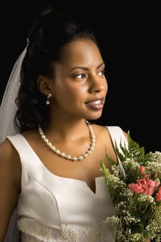 Portrait of a mid-adult African-American bride on black background.