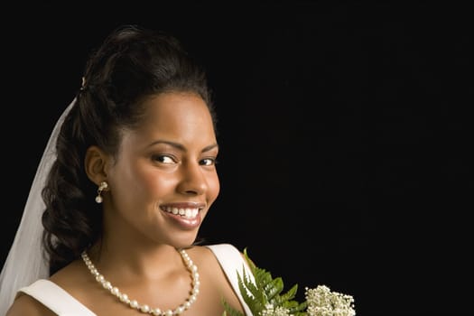 Portrait of a mid-adult African-American bride on black background.