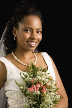 Portrait of a mid-adult African-American bride on black background.