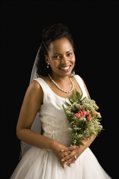 Portrait of a mid-adult African-American bride on black background.