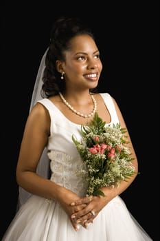 Portrait of a mid-adult African-American bride on black background.