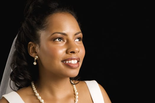 Portrait of a mid-adult African-American bride on black background.