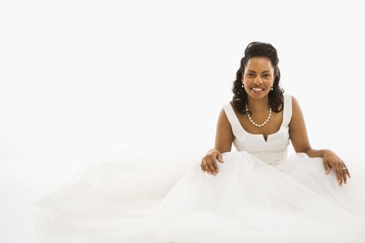 Mid-adult African-American bride on white background.