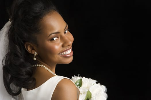 Portrait of a mid-adult African-American bride on black background.