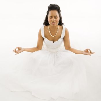 Mid-adult African-American bride mediating with white background.