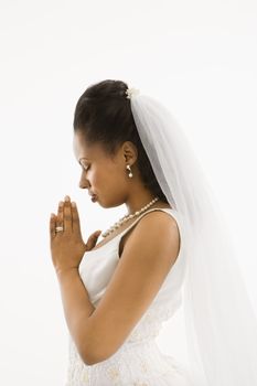 Mid-adult African-American bride praying with white background.