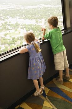 Caucasian young children looking out observation deck at Tower of the Americas in San Antonio, Texas.