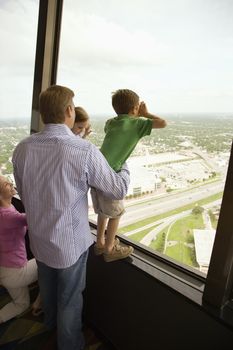 Caucasian family looking out observation deck at Tower of the Americas in San Antonio, Texas.