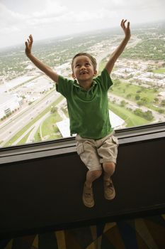 Young Caucasian boy sitting on observation deck at Tower of the Americas in San Antonio, Texas.