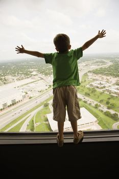 Young Caucasian boy standing on observation deck at Tower of the Americas in San Antonio, Texas.