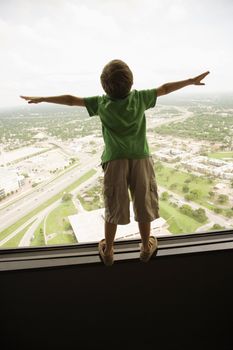 Young Caucasian boy standing on observation deck at Tower of the Americas in San Antonio, Texas.