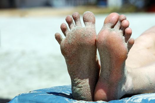 Feet of woman lying on the beach