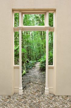 Doorway to a pathway through a lush green forest.