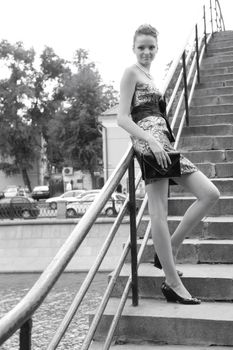 beautiful girl with hand-bag on bridge through river, monochrome