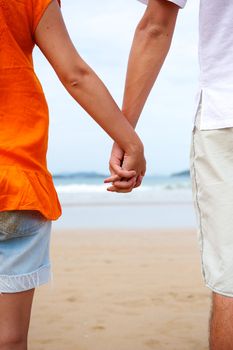 Young couple holding hands on the beach in Brazil