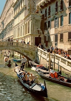 Tourists on foot or in gondolas exploring the delights of Venice.