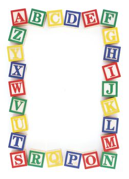 Wooden alphabet blocks arranged to create a frame on a white background