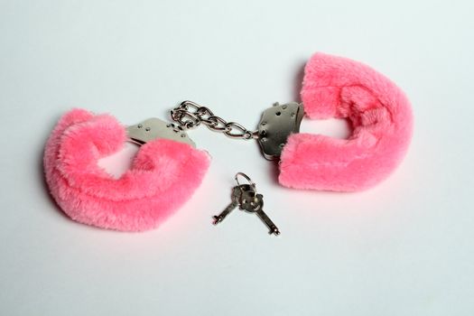 closed handcuff with pink fur and two keys