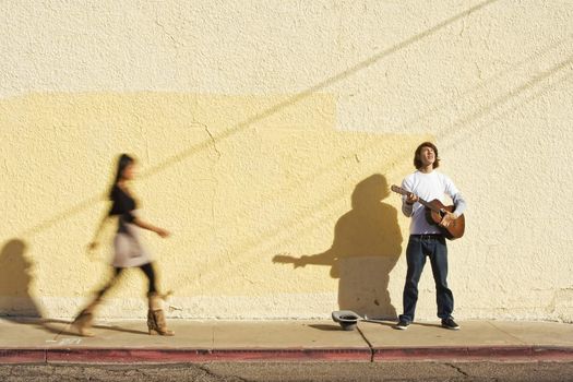 Musician on Sidewalk and Woman Pedestrian 