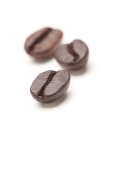 Three Roasted Coffee Beans Isolated on White with Narrow Depth of Field.