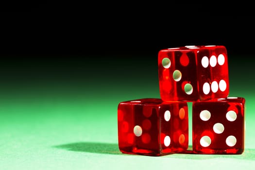 three red dices on green table and black  background