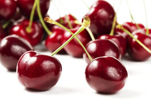two cherries in front of many on white background