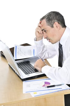 Stressed businessman sitting at his desk isolated on white background