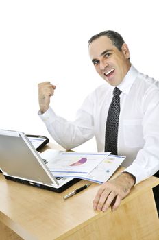 Happy smiling businessman sitting at his desk isolated on white background