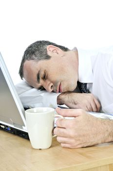 Tired businessman asleep at his desk isolated on white background