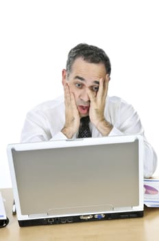 Stressed businessman sitting at his desk isolated on white background