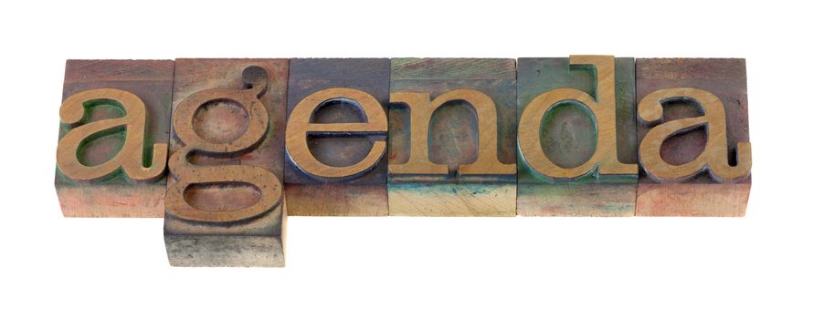 the  agenda word  in vintage wooden letterpress type blocks, stained by color ink, isolated on white