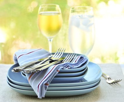 Table setting with stack of plates and cutlery