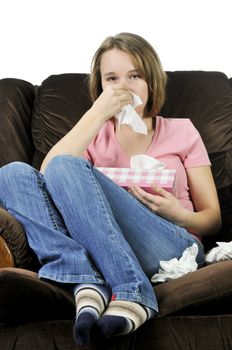 Teenage girl with a cold sitting in a chair with tissue box