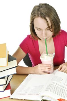 Teenage school girl studying with a milkshake