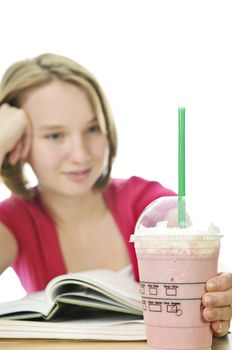 Teenage school girl studying with a milkshake